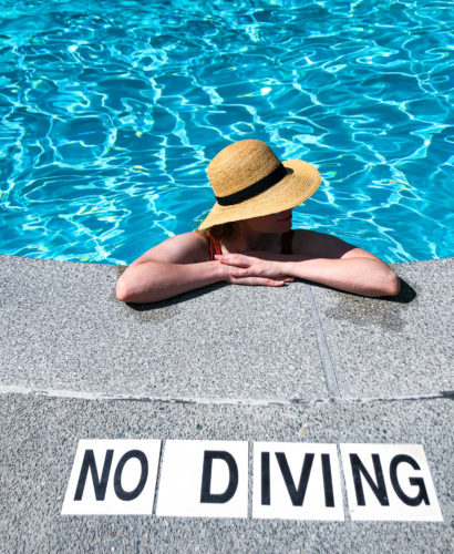 Paula Burrows in pool in front of No Diving Sign